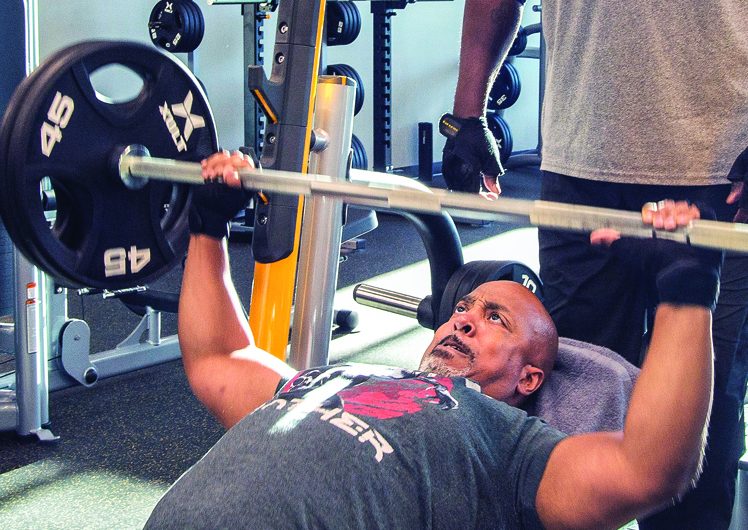 Muscular man lifting heavy weight